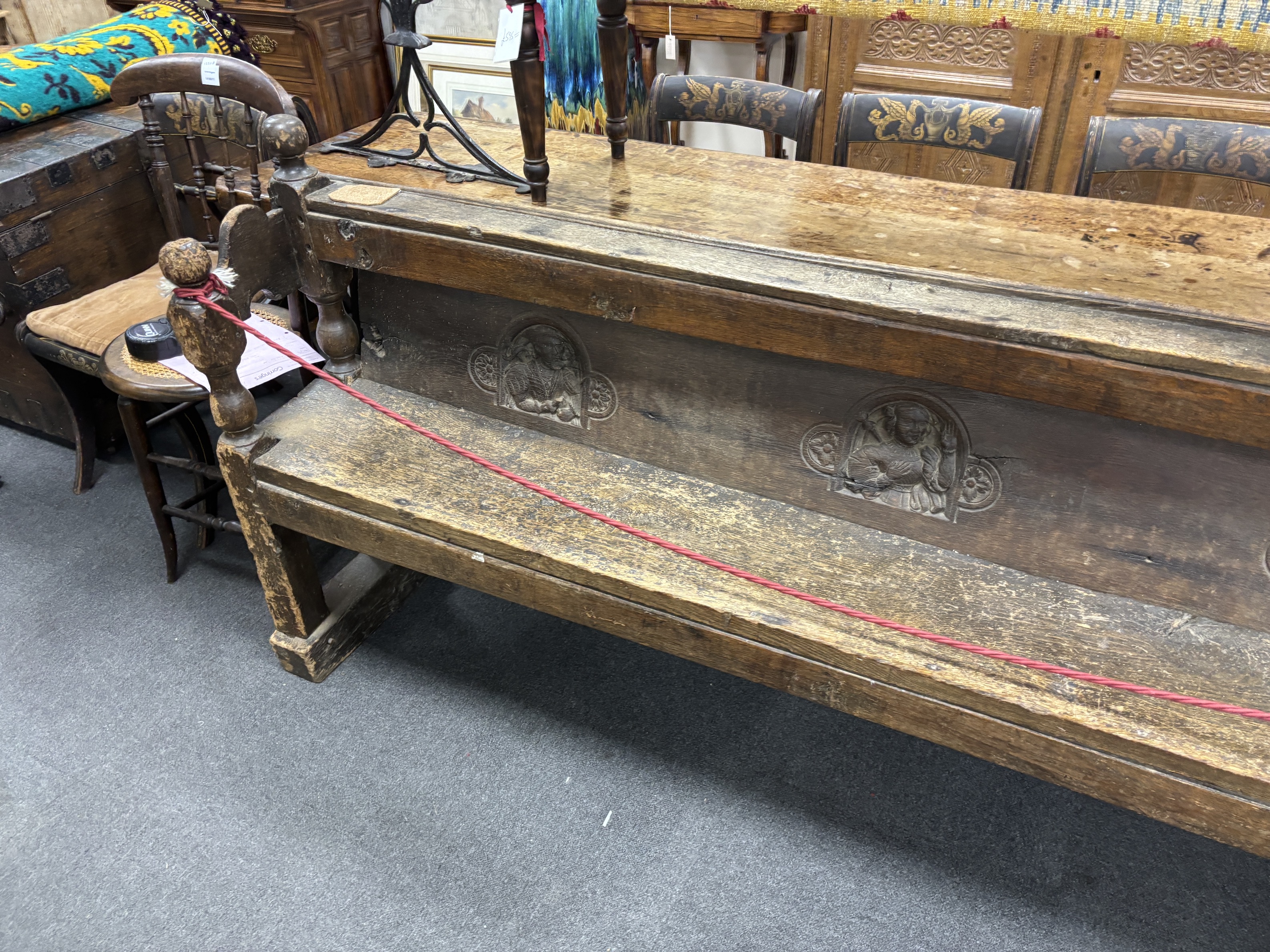An oak pew, inset with three Romayne portrait panels, the panel possibly 16th century, width 220cm, depth 40cm, height 92cm, Provenance- Brede Place, East Sussex, a former residence of the Frewen family from 1712-1936.